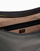 Interior of Guess Camden shoulder bag with logo lining and internal zip pocket