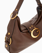 Close-up of gold hardware and Guess script logo on brown Camden shoulder bag