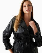 Close-up of snap flap pocket and matte faux leather texture on GUESS trench coat