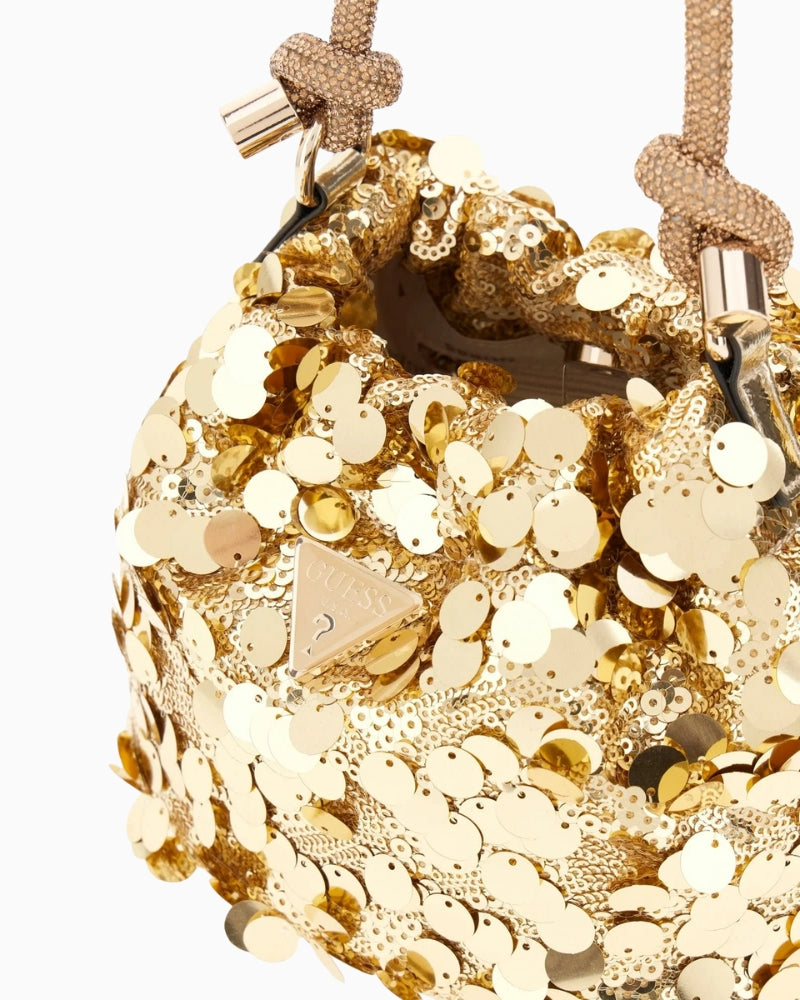 Close-up of Guess logo on metallic gold handbag