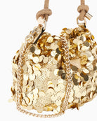 Side view of compact gold handbag with top handle