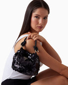 Black sequin mini handbag from GUESS with gold hardware and triangle logo