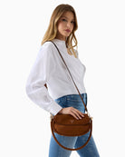 Guess Danya Suede Shoulder Bag in cognac worn crossbody with adjustable strap and flap front detail 1