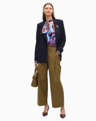 Lola Casademunt blouse styled tucked into trousers with soft bow neckline