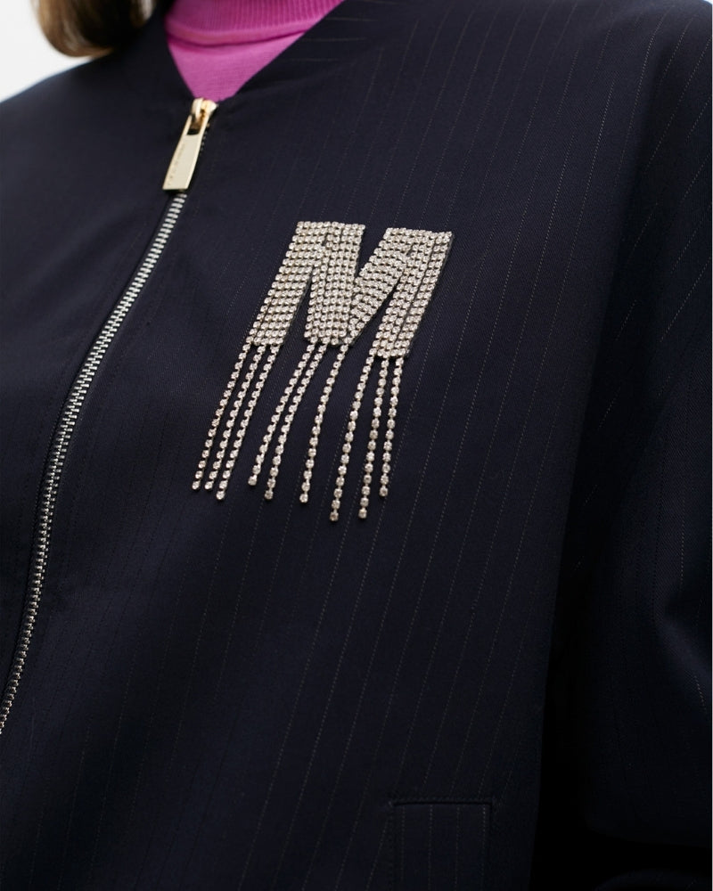 Close-up of sparkling jewel detail on chest and fine pinstripe fabric
