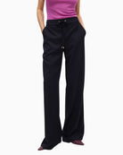 Front view of Lola Casademunt pinstripe trousers with gold detail and elastic waist