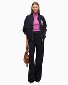 Pinstripe trousers styled with white shirt and blazer for a polished work look