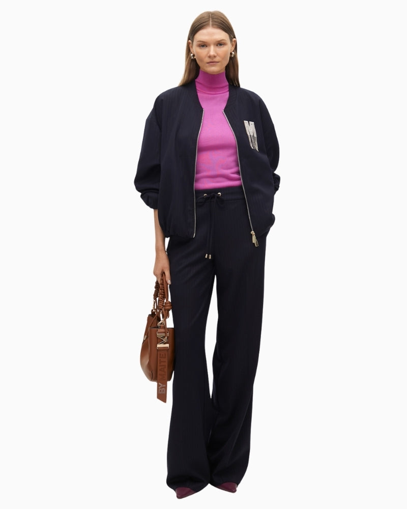 Pinstripe trousers styled with white shirt and blazer for a polished work look