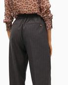 Close-up of high waist and metallic button closure on stretch denim