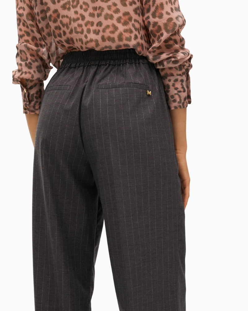 Close-up of high waist and metallic button closure on stretch denim