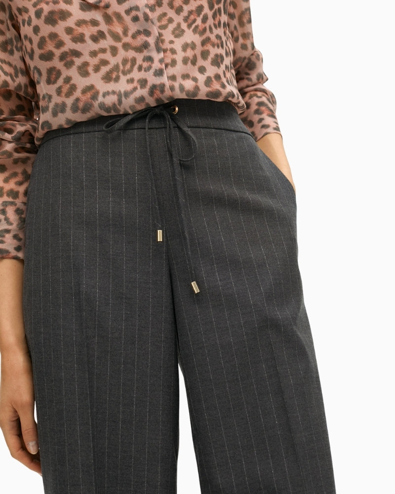 Close-up of high waist and metallic button closure on stretch denim