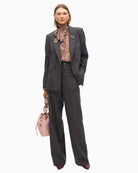 Studded denim jeans styled with a cream blouse and boots for smart-casual wear