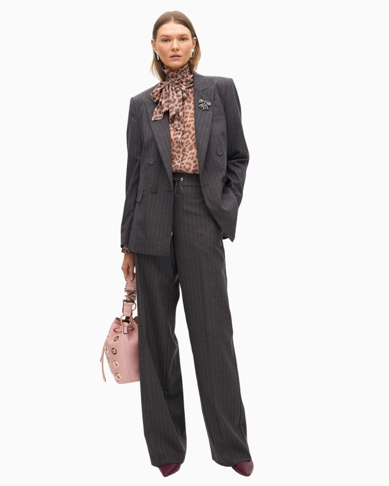 Studded denim jeans styled with a cream blouse and boots for smart-casual wear