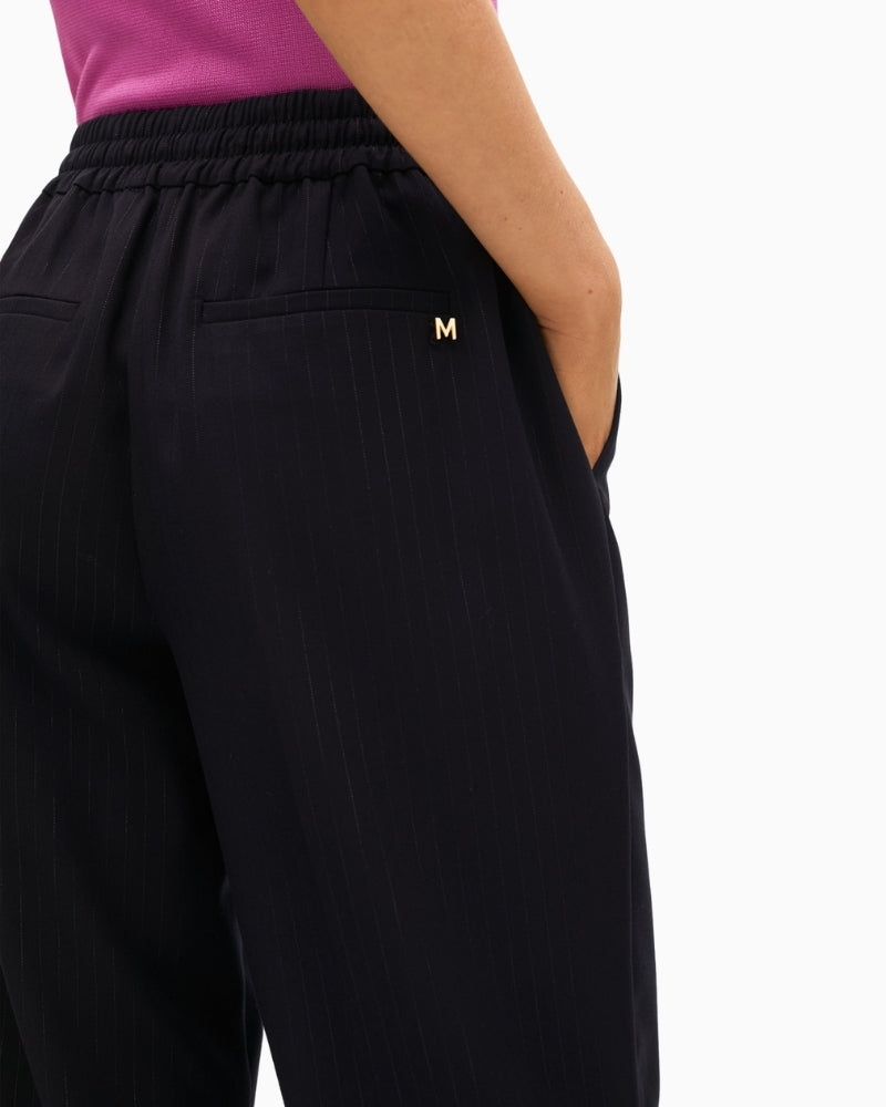 Close-up of waistband with adjustable ties and gold trim