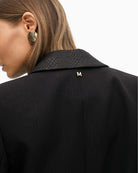 Close up of Cropped structured jacket with bold lapel and tailored shape