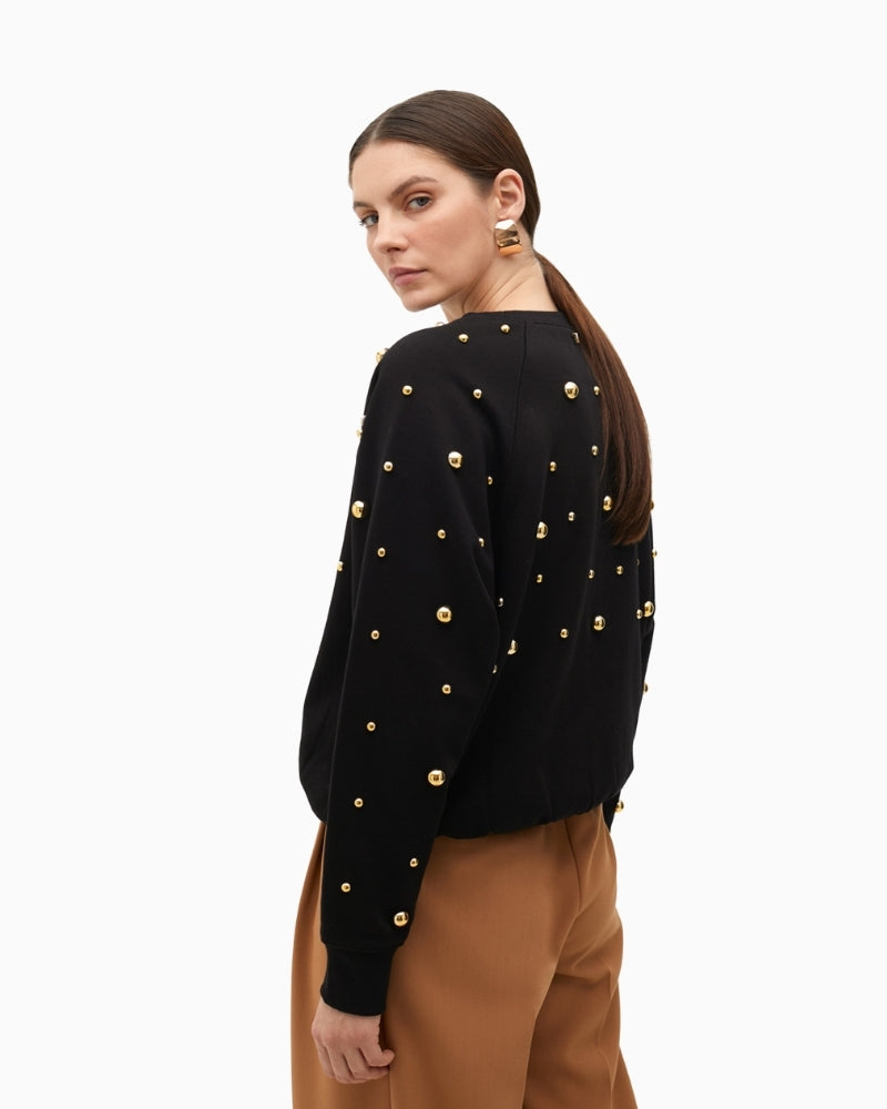 Side of Lola Casademunt cotton sweatshirt with gold stud details and ribbed finish