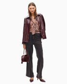 Studded denim jeans styled with a cream blouse and boots for smart-casual wear