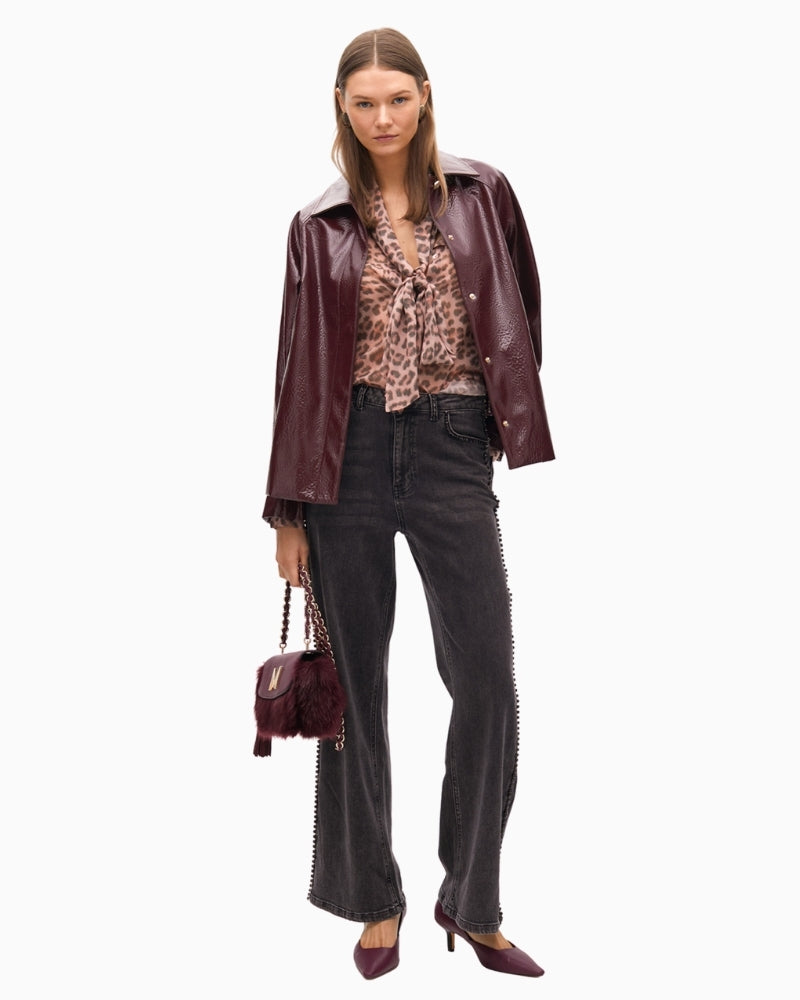 Studded denim jeans styled with a cream blouse and boots for smart-casual wear