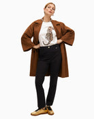 White rhinestone tiger T-shirt styled with beige trousers for a chic casual outfit