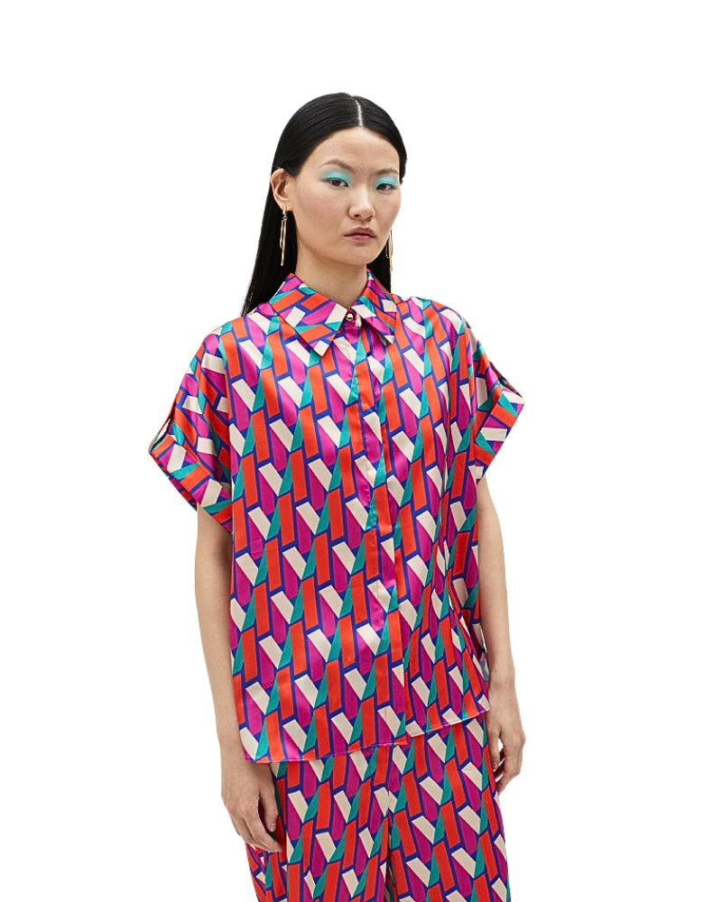 Model wearing Lola Casademunt short-sleeve shirt with bold pink and blue logo print