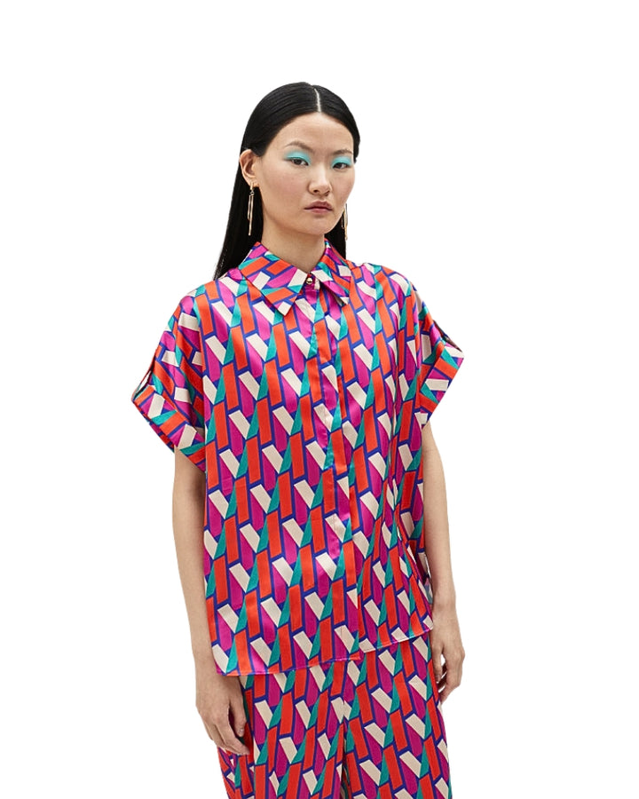 Model wearing Lola Casademunt short-sleeve shirt with bold pink and blue logo print