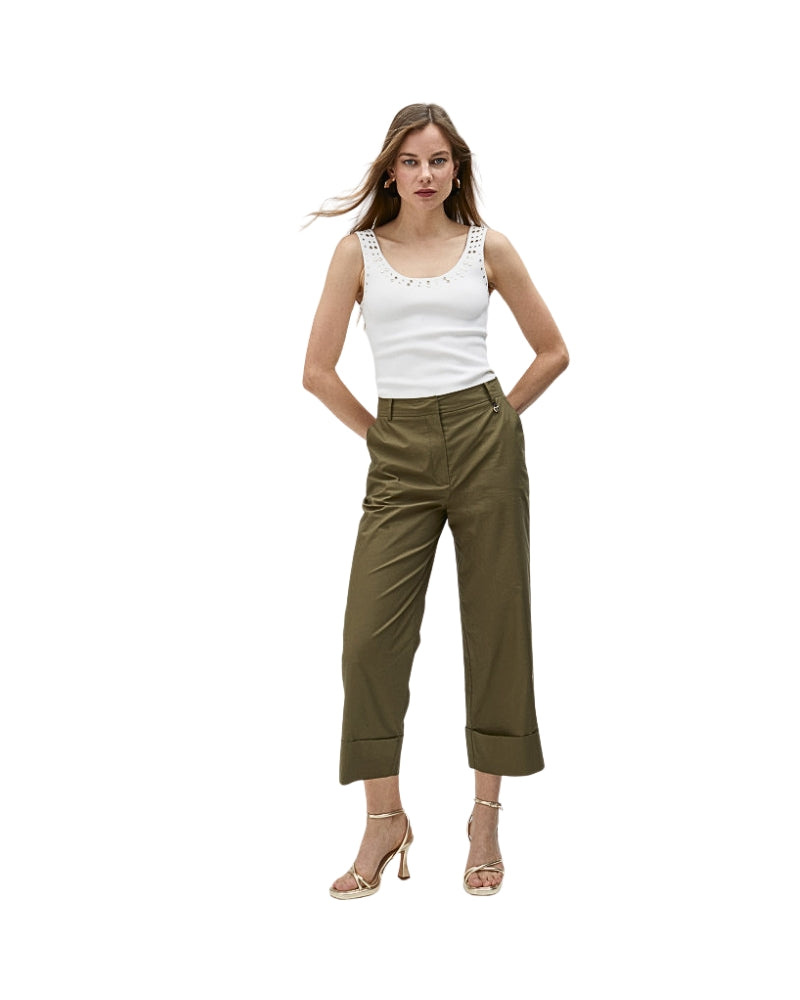Full outfit view of turn-up trousers styled with white tank top and heels