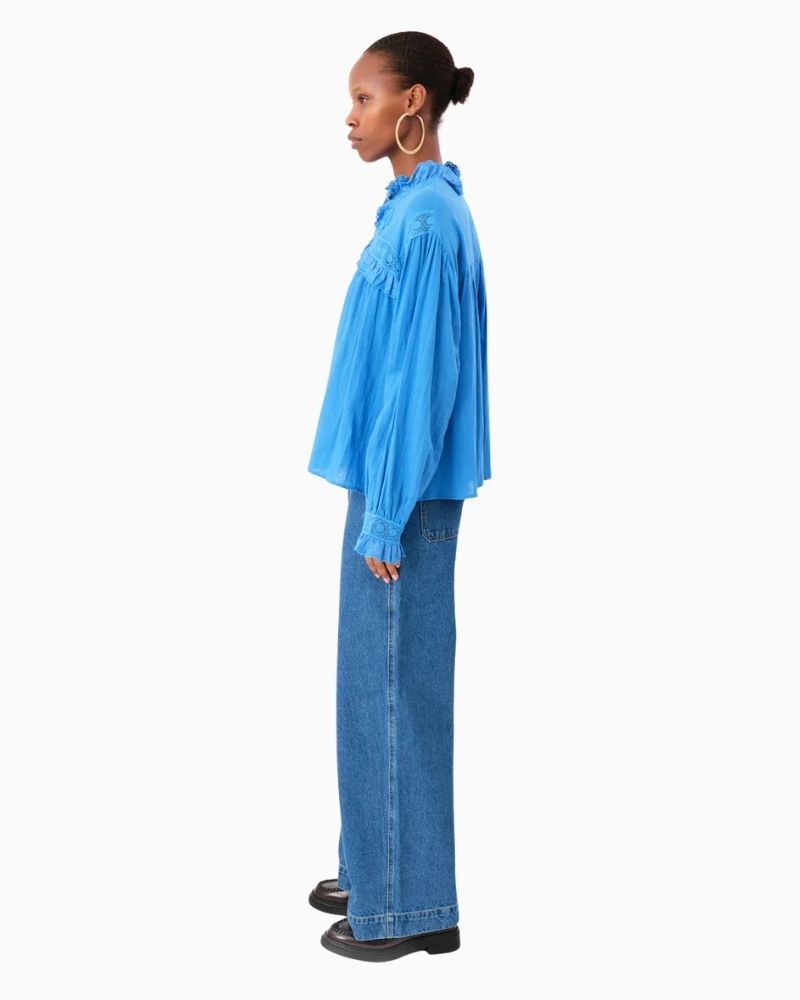 Side of blue blouse showing broderie anglaise yoke and ruffled cuff detail