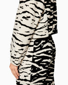 Close-up of ribbed knit collar and subtle animal pattern on black fabric