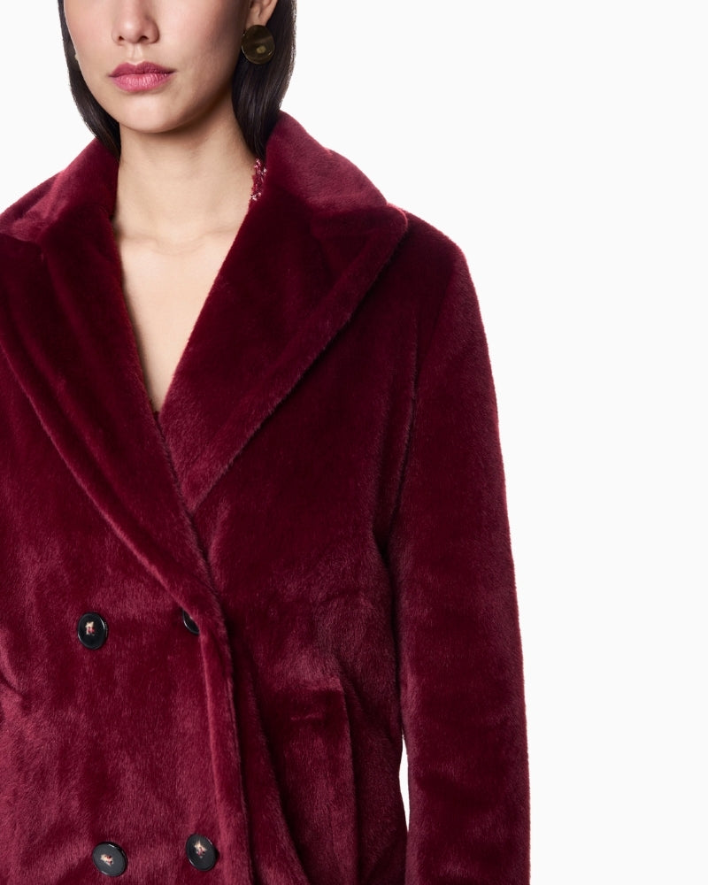 Close-up of button and pocket detail on soft maroon Marc Cain coat