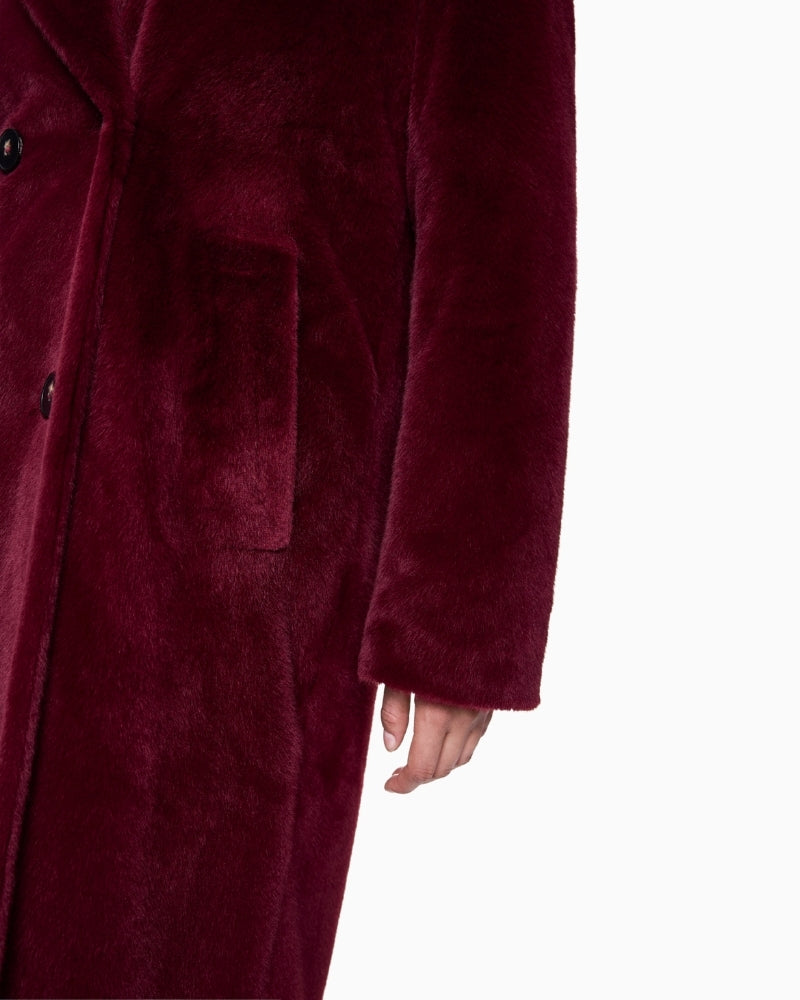 Close-up of button and pocket detail on soft maroon Marc Cain coat