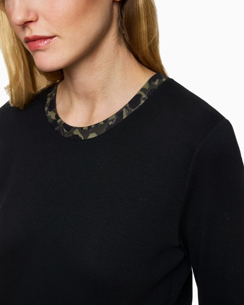 Close up of Marc Cain black jersey shirt with printed trim at neckline and rolled sleeves