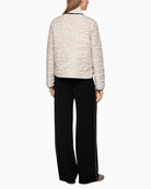 Back of short quilted jacket showing contrast seams and structured shape