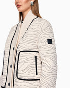 Side view showing zip pockets and cropped silhouette of quilted jacket