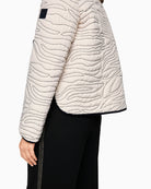 Close-up of zebra print buttons on Marc Cain cream jacket