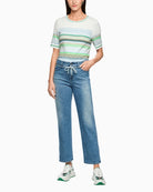Woman wearing Marc Cain blue denim pants styled with striped top – Áines Boutique