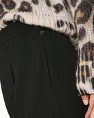 Close-up of waistband, fastening button and subtle crease detail on Marc Cain trousers