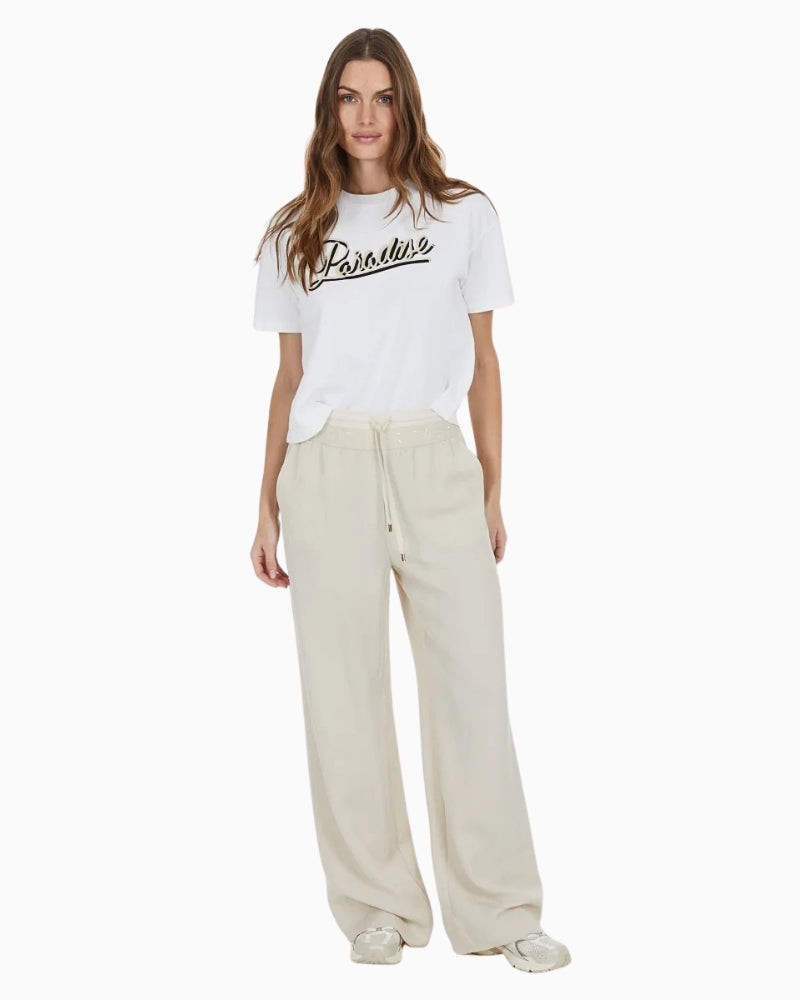 Styled outfit pairing the tee with high-waisted trousers
