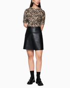 Model styling animal print T-shirt with black leather skirt