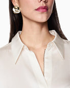 Detail of smooth silk fabric and structured collar on women’s blouse