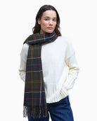 Model wearing navy green tartan scarf draped over neutral outfit