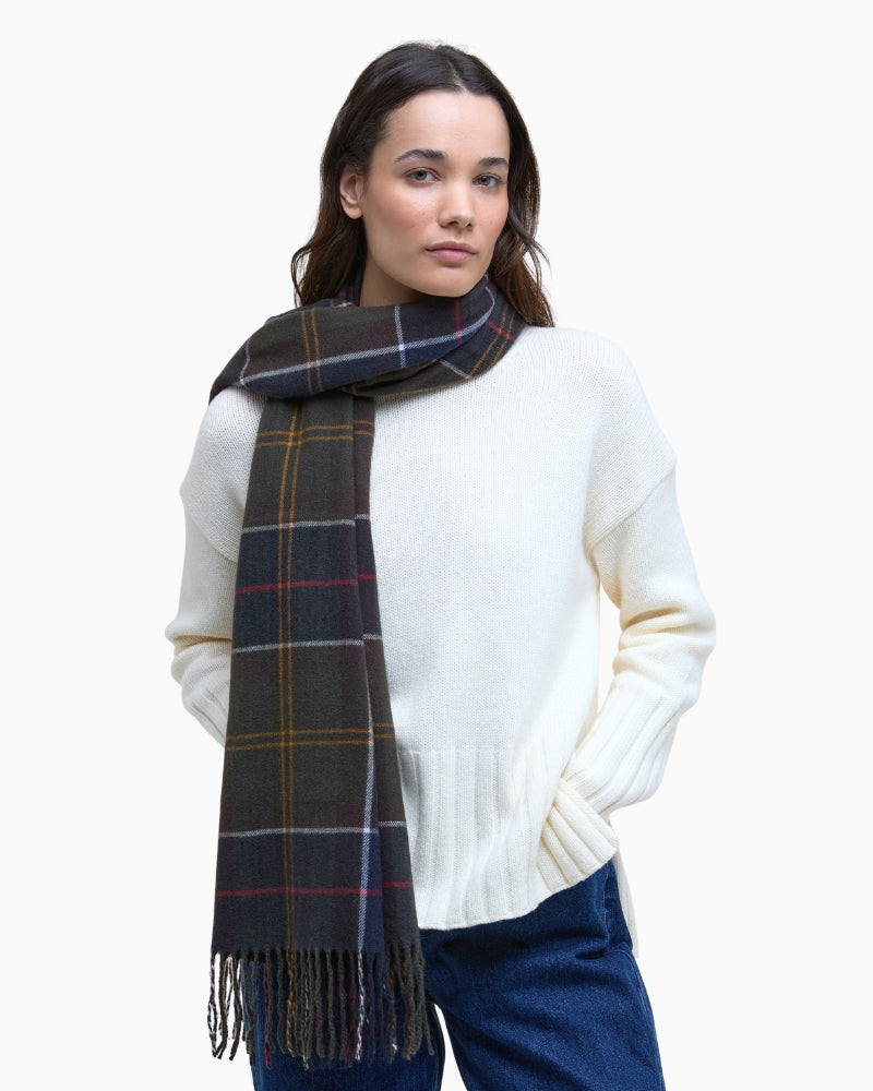 Model wearing navy green tartan scarf draped over neutral outfit
