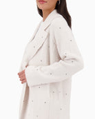 Side view of Monari coat showing relaxed fit and stud trim