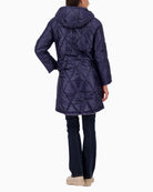 Back view showing extended hem of beige reversible coat