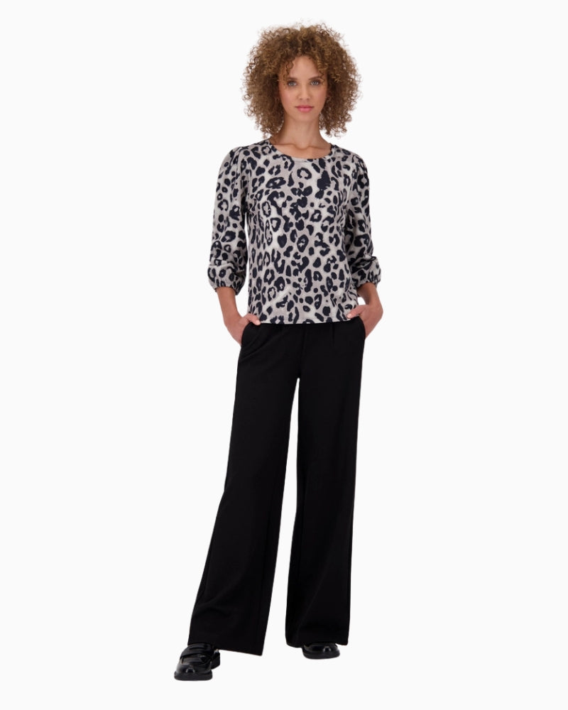 Model wearing leopard print Monari sweatshirt with light trousers in black