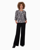 Model wearing leopard print Monari sweatshirt with light trousers in black