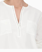 Close-up of rhinestone trim at neckline on Monari white blouse
