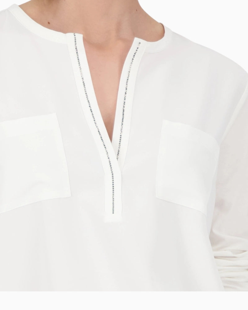 Close-up of rhinestone trim at neckline on Monari white blouse