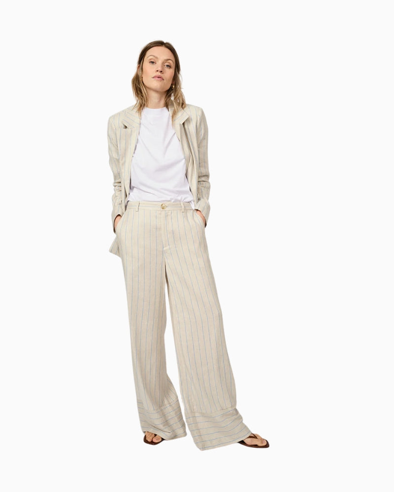 Woman wearing beige wide-leg striped trousers with a relaxed fit