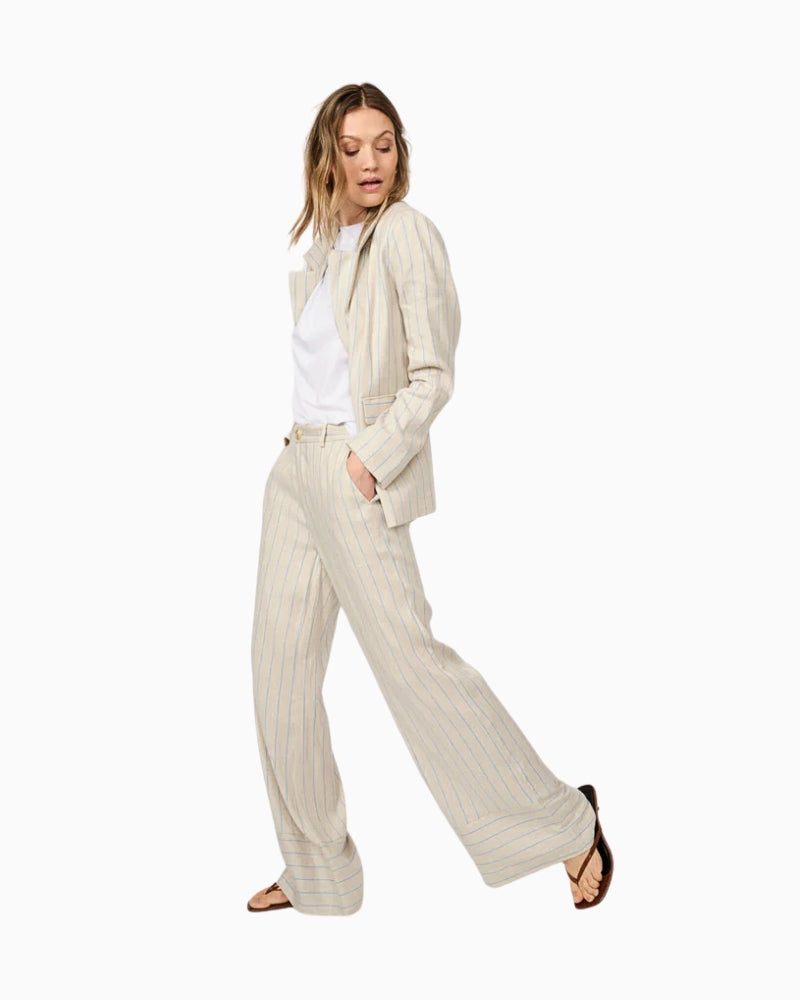 Side view of beige striped trousers on model in motion