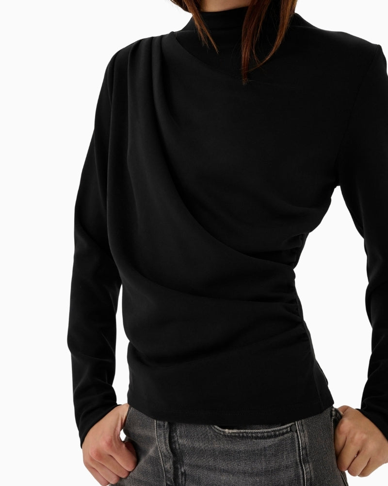 Close-up of soft fabric texture and gentle drape on MEW black blouse